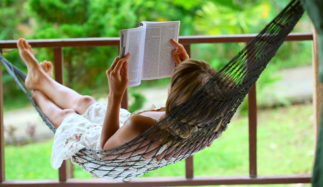 a woman reading in a hammock enjoy nature in a peaceful setting